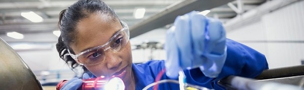 Woman working on wiring holding a torch