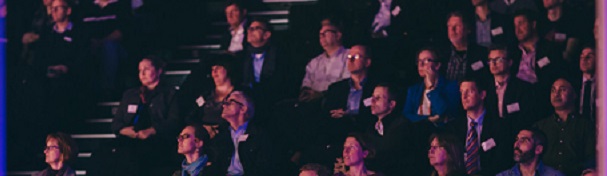 Audience in tiered seats watching event