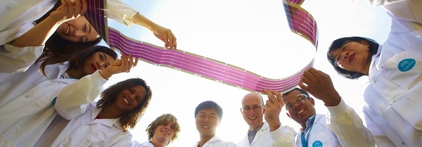 Group of scientists all holding a ribbon together