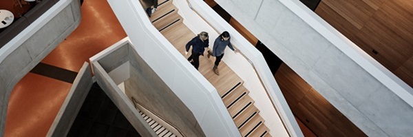 Two people walking down a staircase