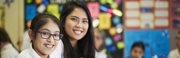 Pupil and teacher smiling in class