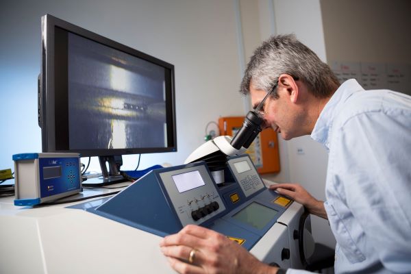 Man looking down microscope