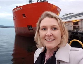 Haylea Miller standing in front of a red ship.