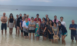 Nineteen people from the Environomics Future Science Platform team standing in knee-deep water on a beach on Rottnest Island.