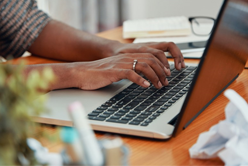 A pair of hands typing at a keyboard.