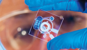close up photo of a scientist holding a glass slide used to create polymers