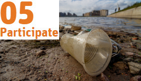 Plastic cup and other waste washed up on shoreline.
