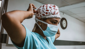 medical professional putting on a surgical face mask