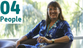 Eva Plaganyi smiling at camera sitting on a chair in front of a window