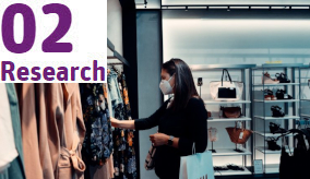 person in a face mask shopping in a clothes store