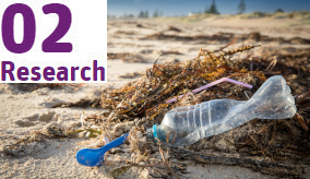 close up of plastic bottle and other rubbish on the beach