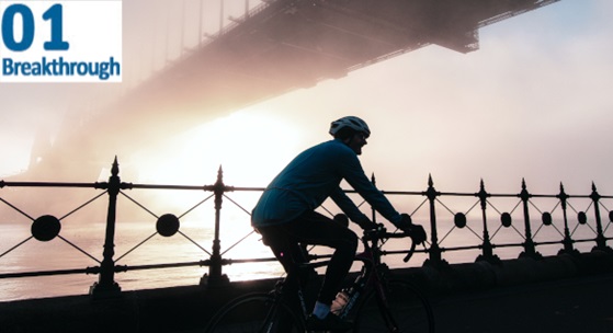 A person riding a bike next to the Sydney Harbour 