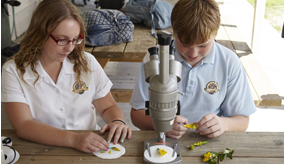 Two students with a microscope