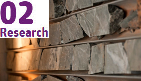 Slabs of rock-like metals on half pipes being fed into a virtual core machine.